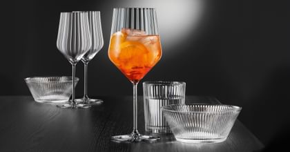 NACHTMANN Aperitivo Spritz glass filled with a cocktail. Next to it are the matching bowl and a drinking glass.