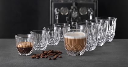 Four NACHTMANN Barista Noblesse espresso glasses and four NACHTMANN Barista Ethno latte macchiato glasses, with the front glass of each filled