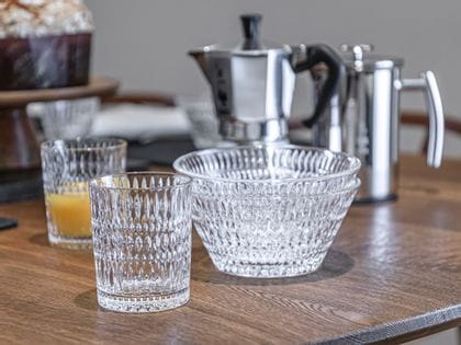 The NACHTMANN Ethno tumbler next to two stacked bowls. In the background are a with orange juice filled NACHTMANN Ethno tumbler and an Italian coffee maker.<br/>