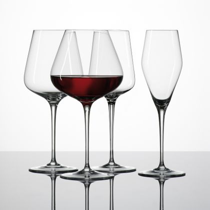 The SPIEGELAU Hybrid crystal glass series, showing a with red wine filled Burgundy glass and the empty Bordeaux glass, Red Wine glass and Champagne glass.<br/>