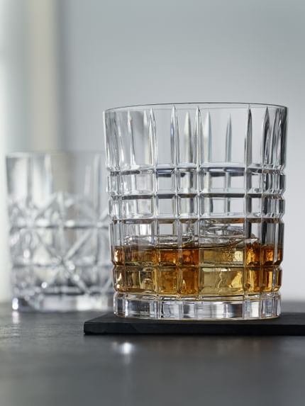 The NACHTMANN Highland tumblers in different cut patterns, the tumbler with the Square pattern filled with whisky on the rocks.<br/>